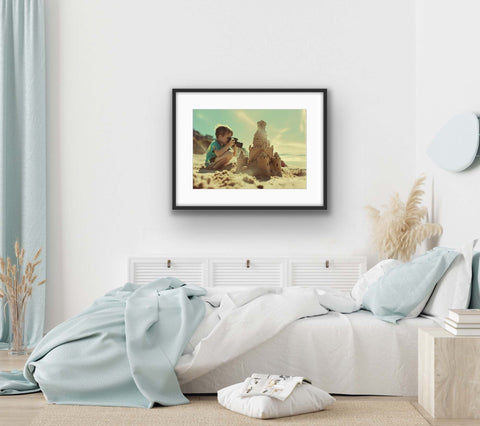 Framed poster of a vintage kid at the beach with sandcastle, adding warmth and whimsy to decor.