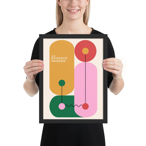 Framed poster Bauhaus 12 with geometric abstract design held by a person.