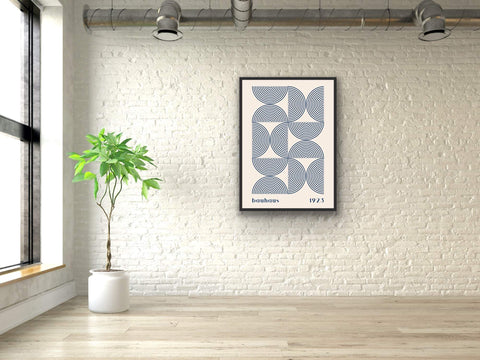 Framed poster with Bauhaus geometric design on a white brick wall.