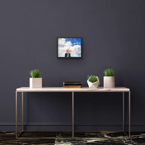 Framed art print of "Windswept" by Joyce Yiu on black wall, modern decor, plants, and table.