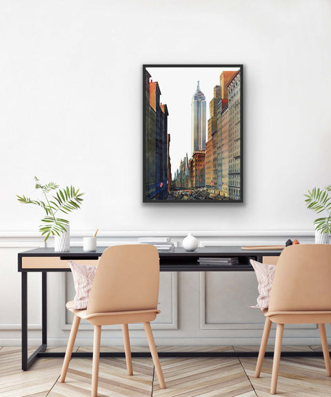 Framed matte paper poster with urban cityscape scene hanging on a wall above a stylish desk.