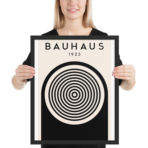 Framed poster with Bauhaus 1923 design, bold black and white geometric shapes, concentric circle motif.